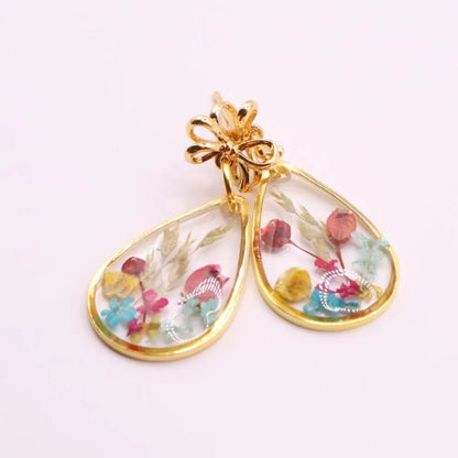 Gold earrings with colorful floral design on a white background