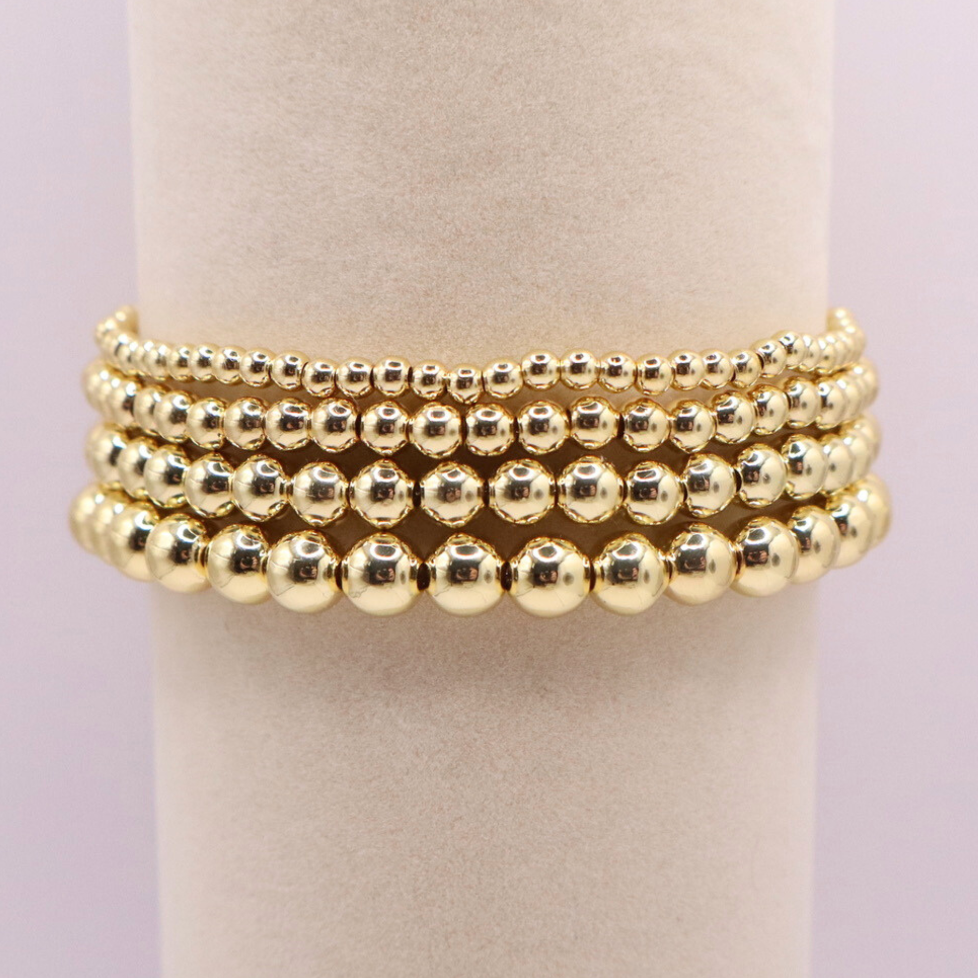 18k gold filled beaded bracelets stacked together featuring polished round beads in varying sizes on a neutral display background