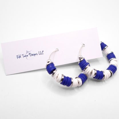 Handmade royal blue and white polymer clay heishi bead hoop earrings with silver spacers shown on a white background with display card