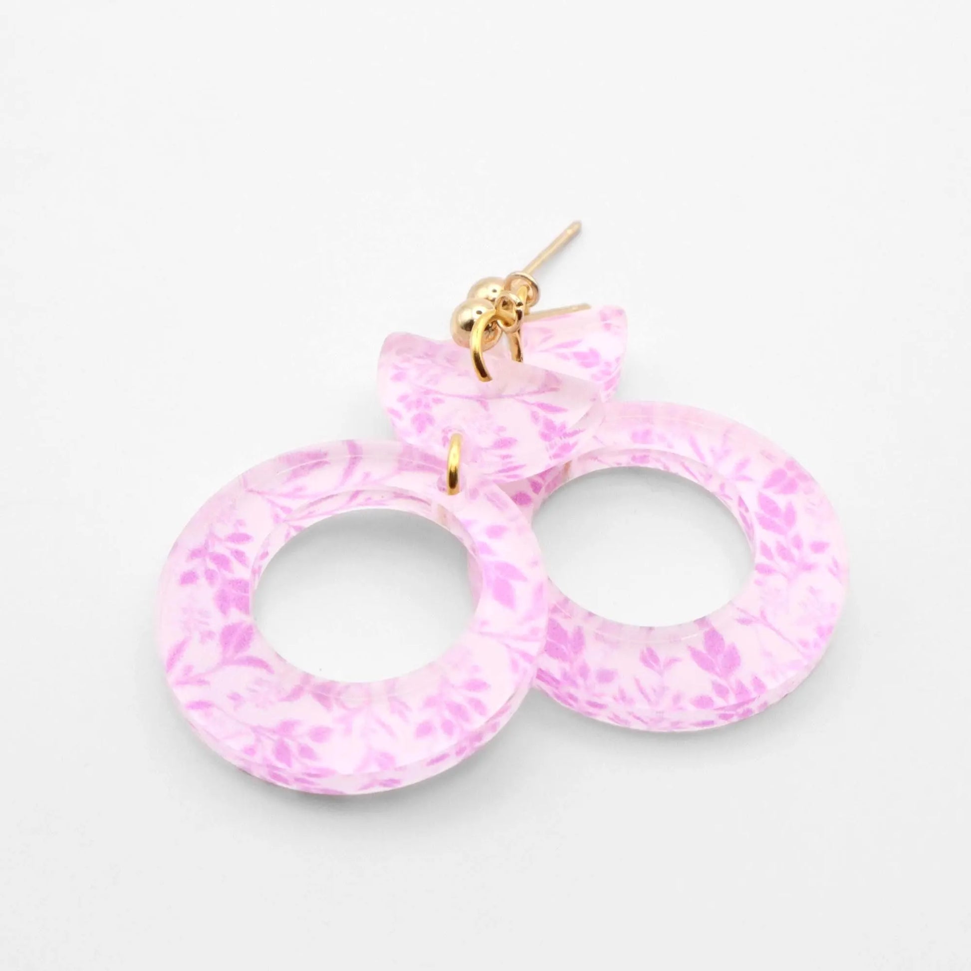 Pink marbled earrings on a light gray background