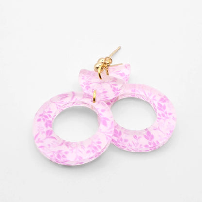 Pink marbled earrings on a light gray background