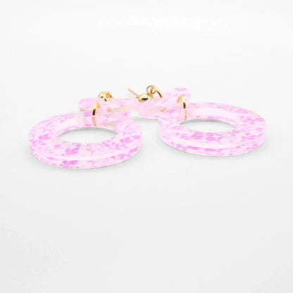 Pink hoop earrings on a white background