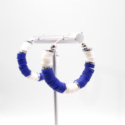 Royal blue and white heishi bead hoop earrings with silver accents displayed on a branded card against a clean white background