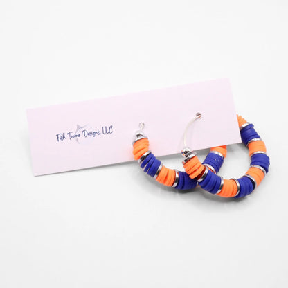 Handmade blue and orange polymer clay heishi bead hoop earrings with silver spacers shown on a white background with display card