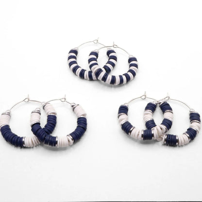 Set of three navy blue and white heishi bead hoop earring styles arranged on a white background, showcasing size and pattern variations