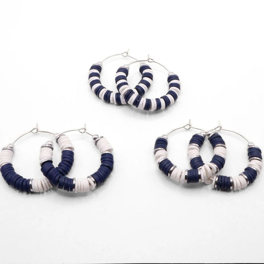 Set of three navy blue and white heishi bead hoop earring styles arranged on a white background, showcasing size and pattern variations