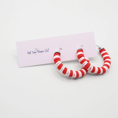 Red and white heishi bead hoop earrings with silver accents displayed on a branded card against a white background