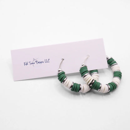 Handmade green and white polymer clay heishi bead hoop earrings with silver spacers shown on a white background with display card