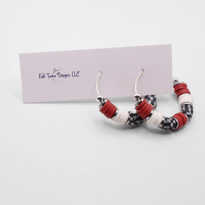 Handmade crimson and houndstooth polymer clay heishi bead hoop earrings with silver spacers shown on a white background with display card
