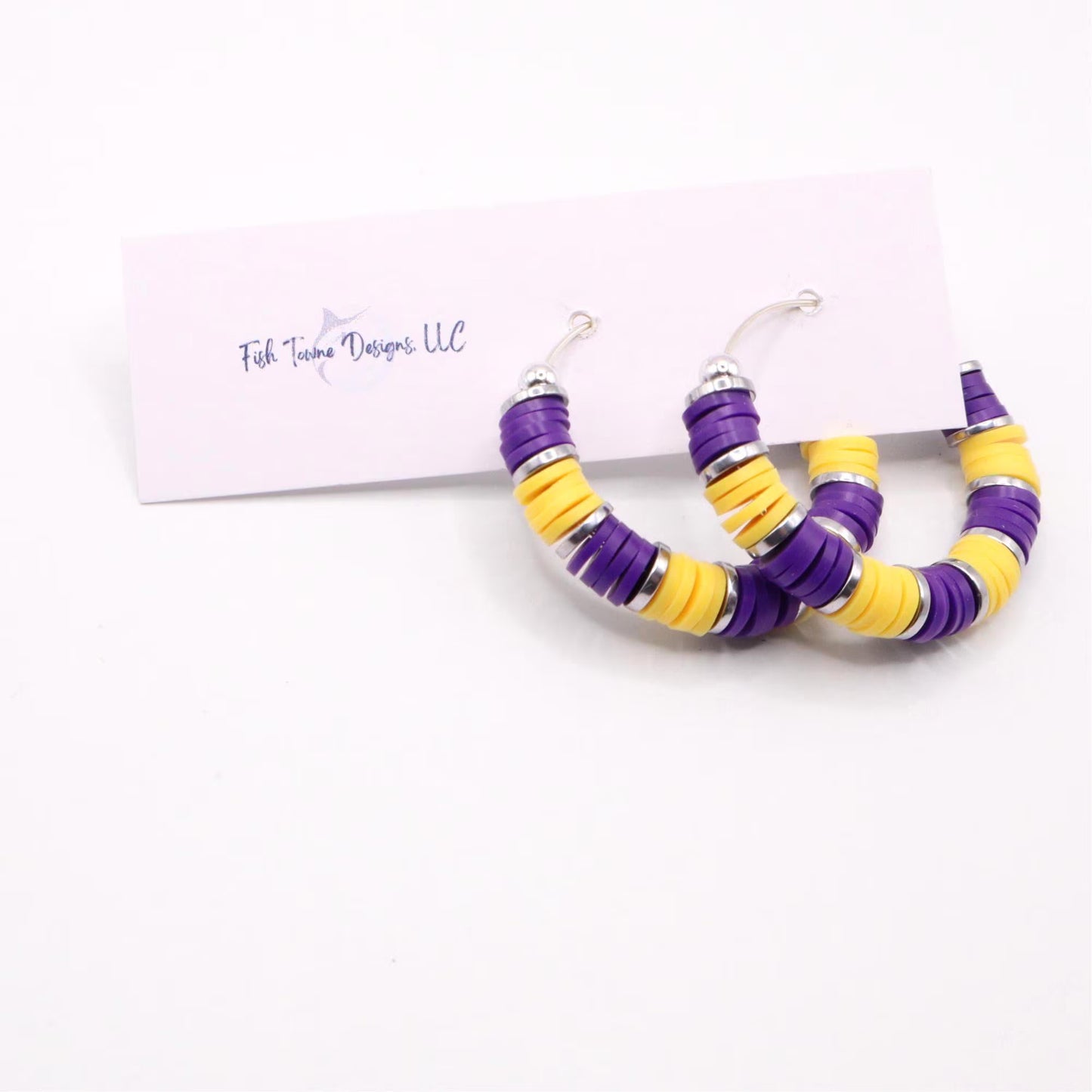 Handmade purple and gold polymer clay heishi bead hoop earrings with gold spacers shown on a white background with display card