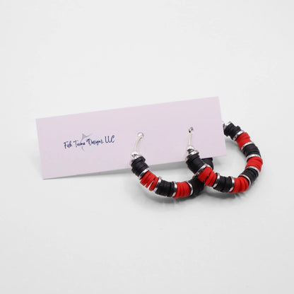 Red and black heishi bead hoop earrings with silver accents displayed on a branded card against a clean white background
