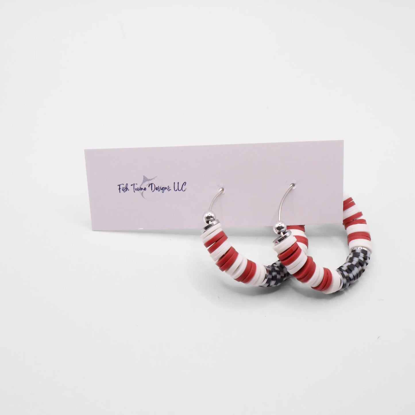 Crimson and houndstooth heishi bead hoop earrings with silver accents displayed on a branded card against a white background
