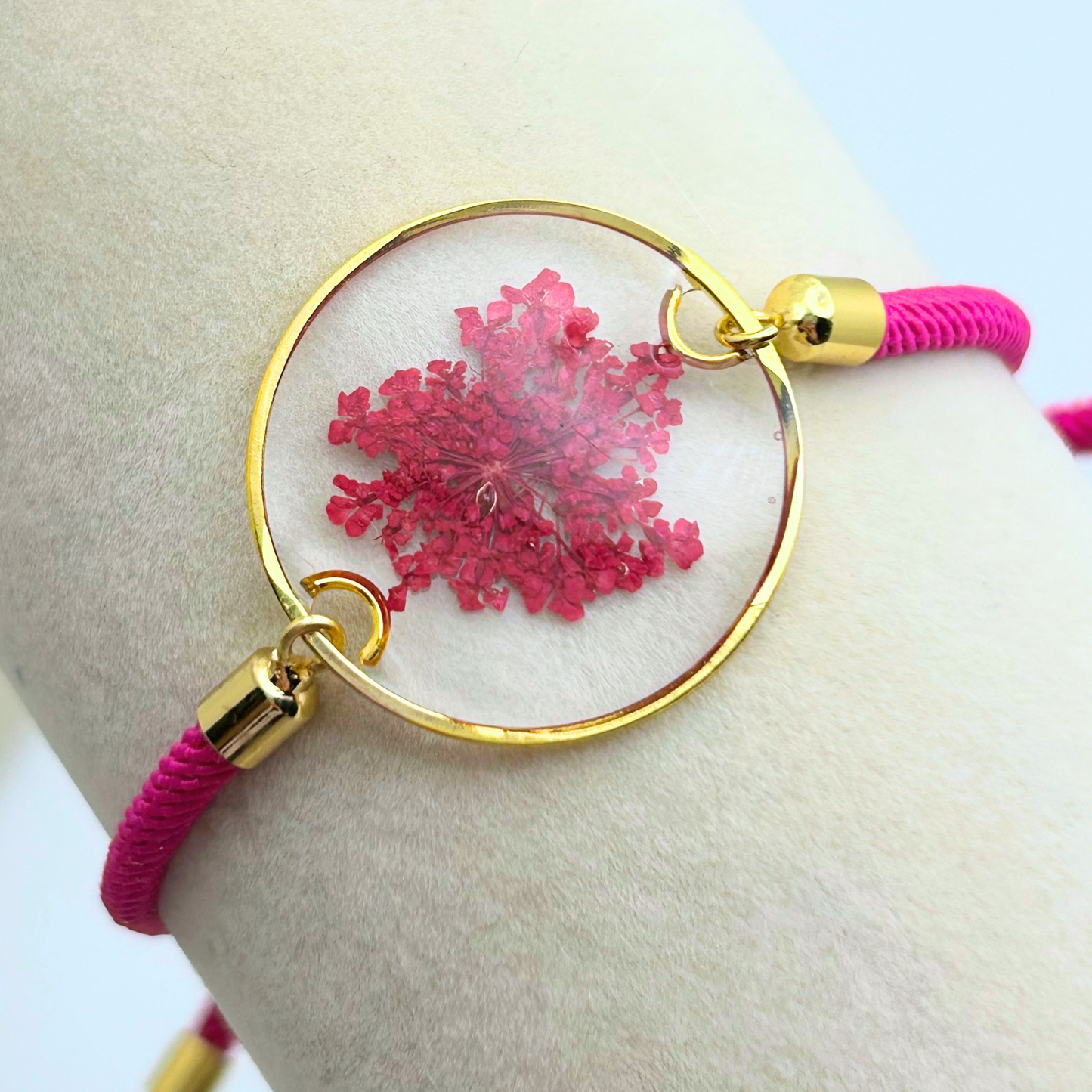 Bracelet with pink floral design and gold accents on a wrist