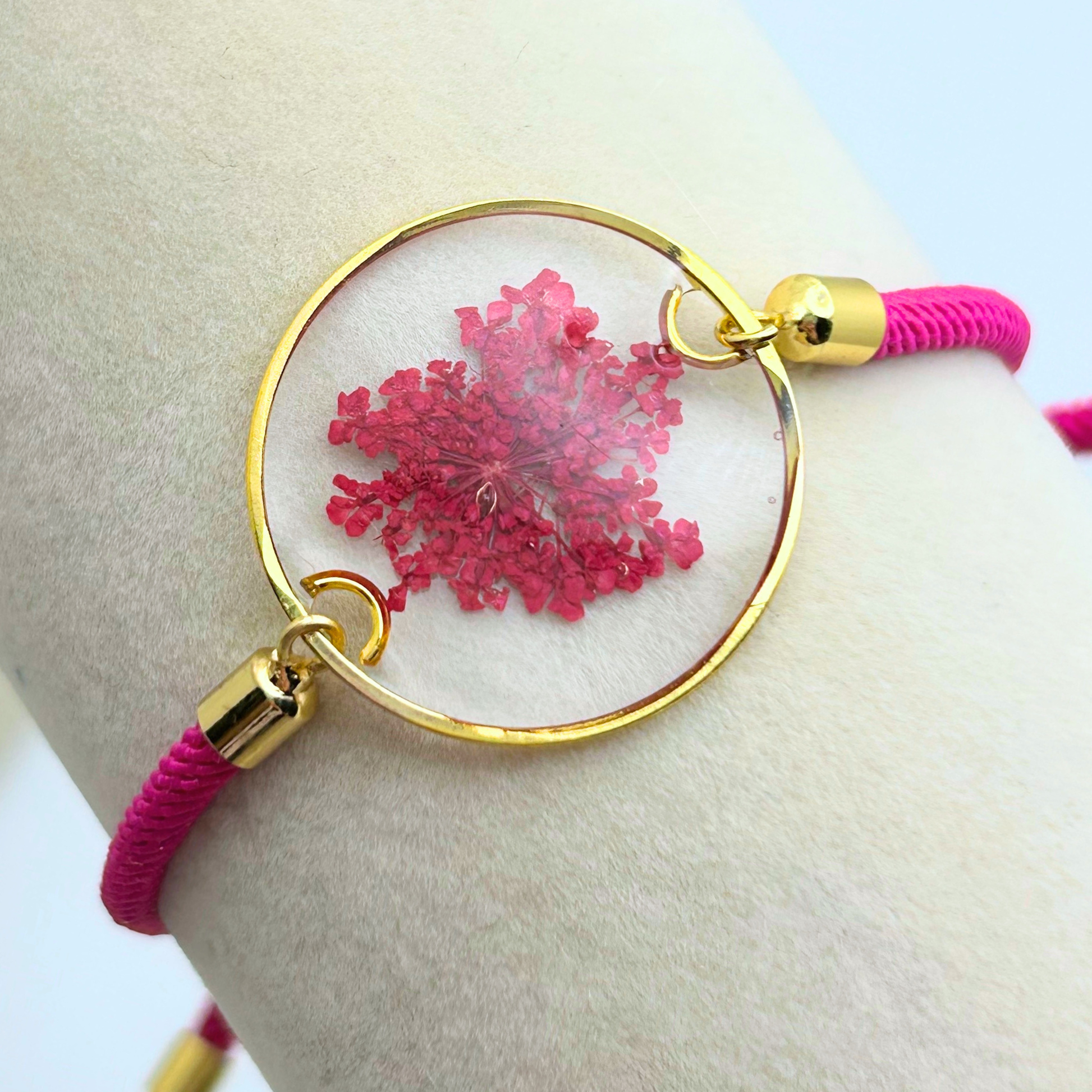 Bracelet with pink floral design and gold accents on a wrist
