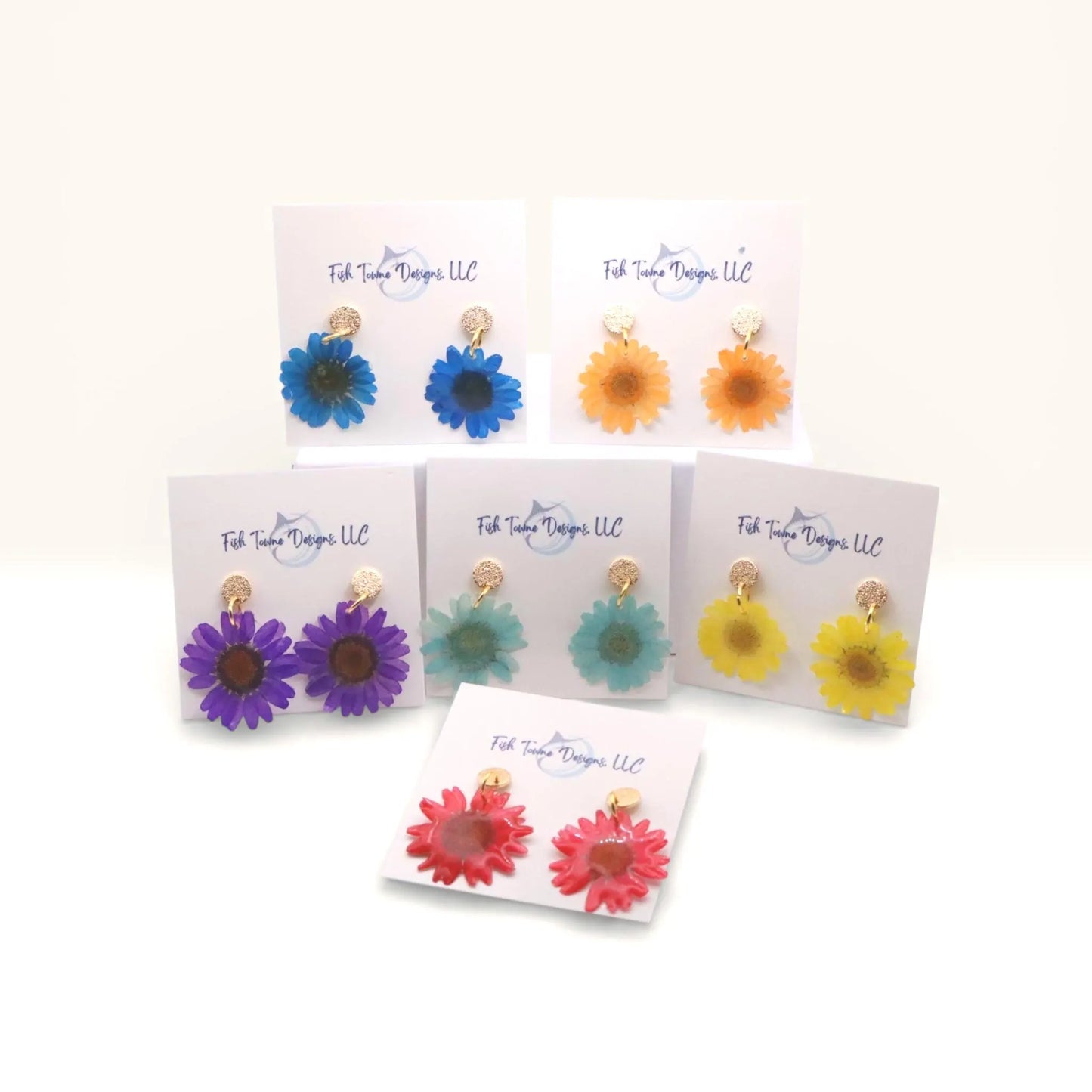 Set of colorful flower-shaped earrings on display cards with 'Fish Towne Designs, LLC' branding.